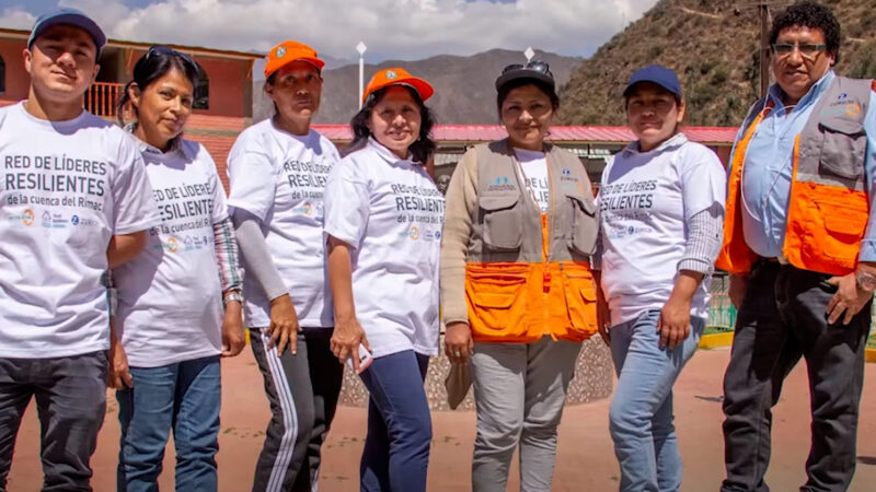 Eva's group of people in orange shirts posing for a photo.