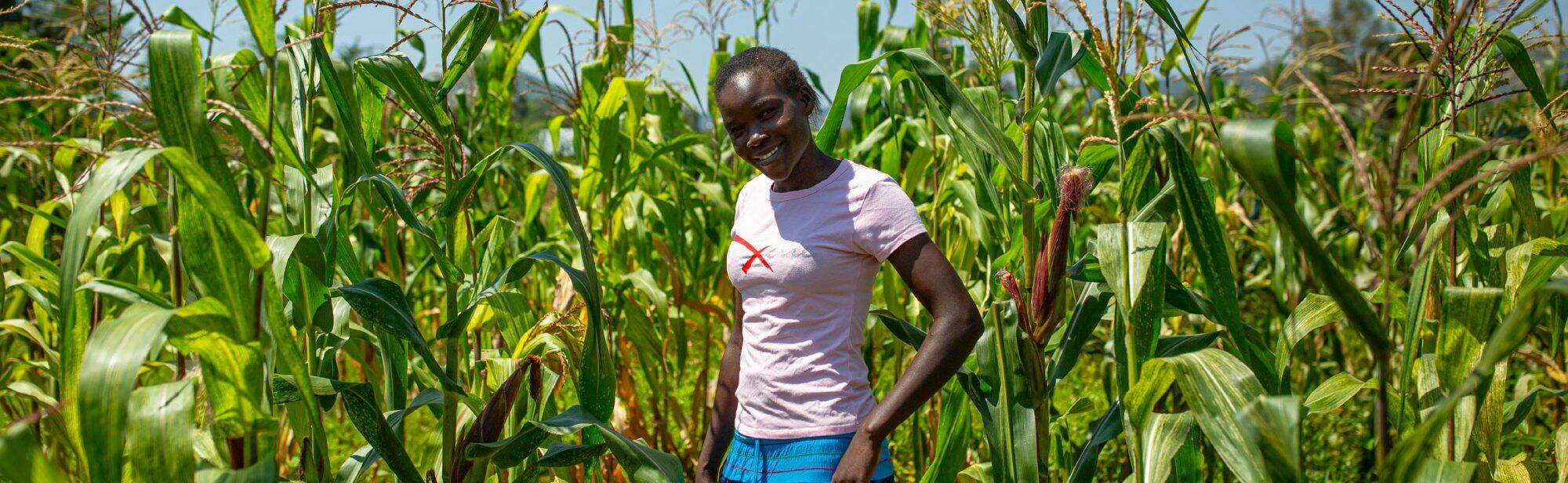 A woman working in a field of corn.
