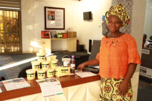 An empowered woman from Burkina Faso standing confidently in front of a counter, harnessing the power of energy.