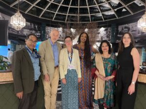 A group of people posing for a photo during the 2023 UN Climate Change Conference in a lobby.