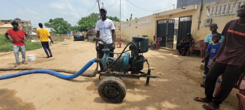 A hopeful group of people standing around a water pump in West Africa.