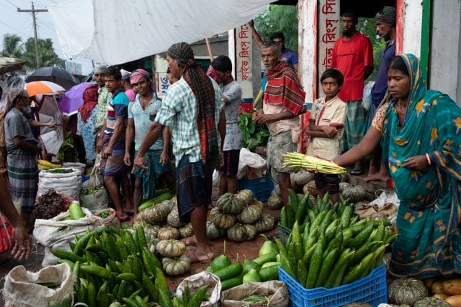 A group of people shopping environmentally friendly at an outdoor market.