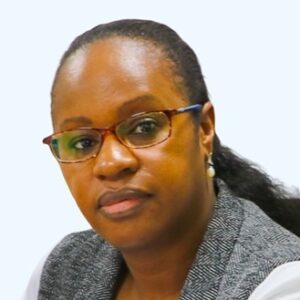 Susan Maina, a focused woman with glasses in professional attire against a light background.