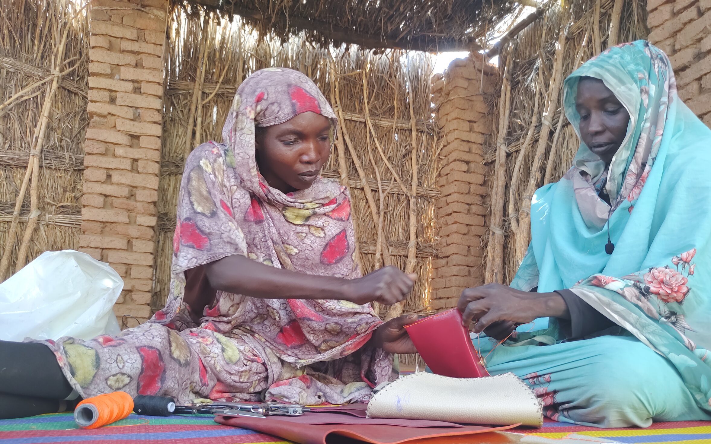 Two women in Darfur, making handbags using new skills taught by practical action.