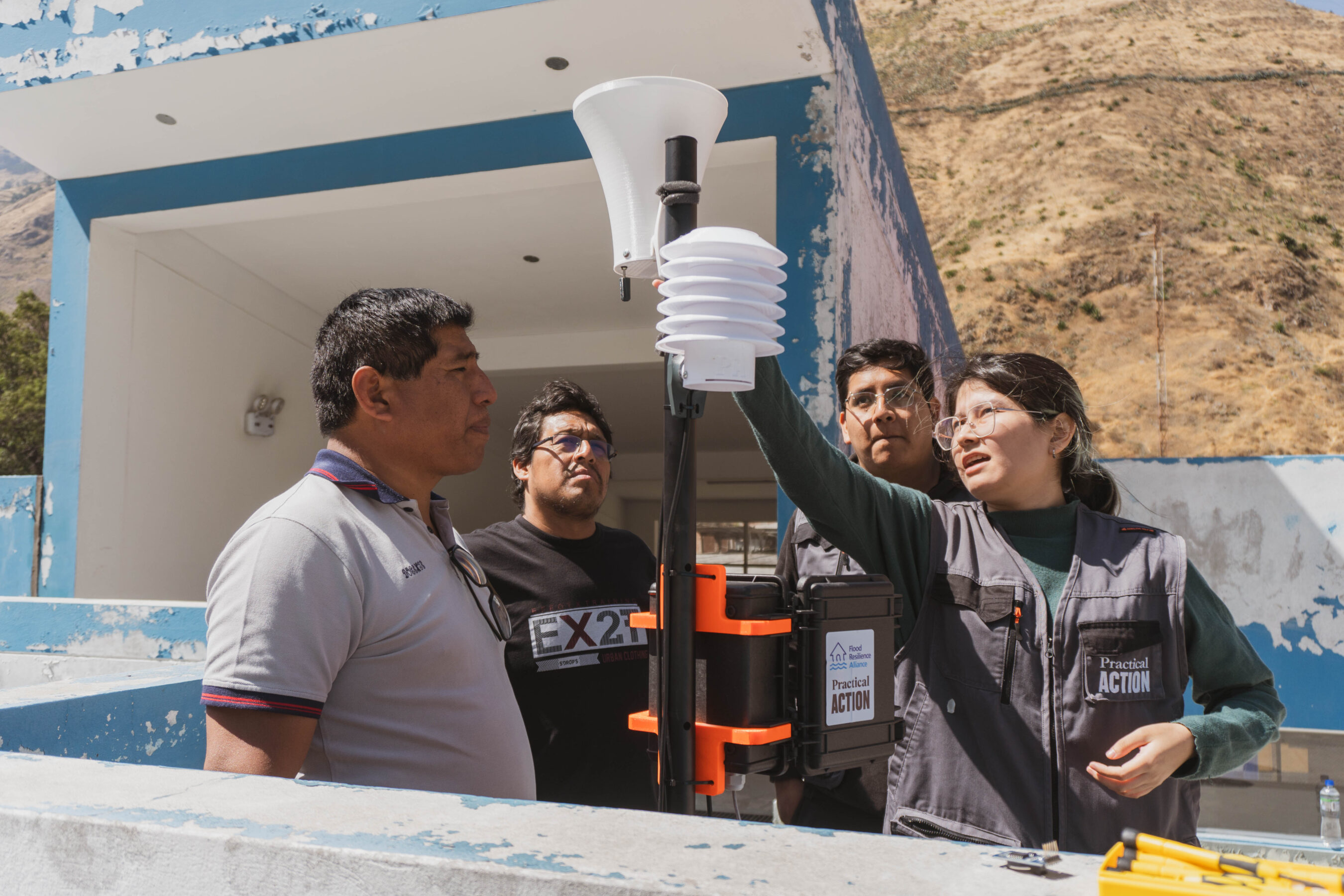 Practical Action team members and local authorities install a climate station.