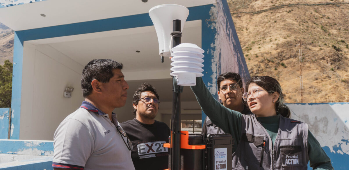 Practical Action team members and local authorities install a climate station.