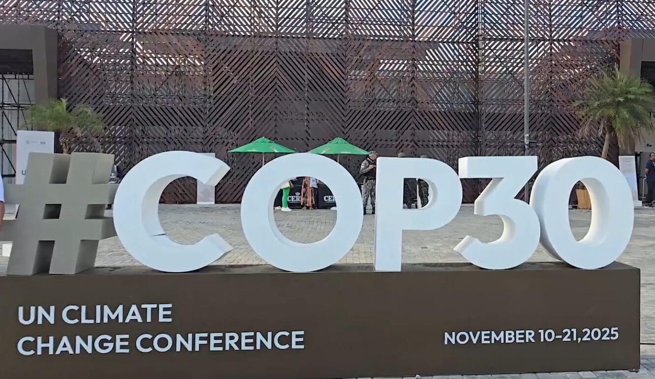 Large "#COP30" sign in front of a modern building, with text below reading "UN Climate Change Conference, November 10-21, 2025.