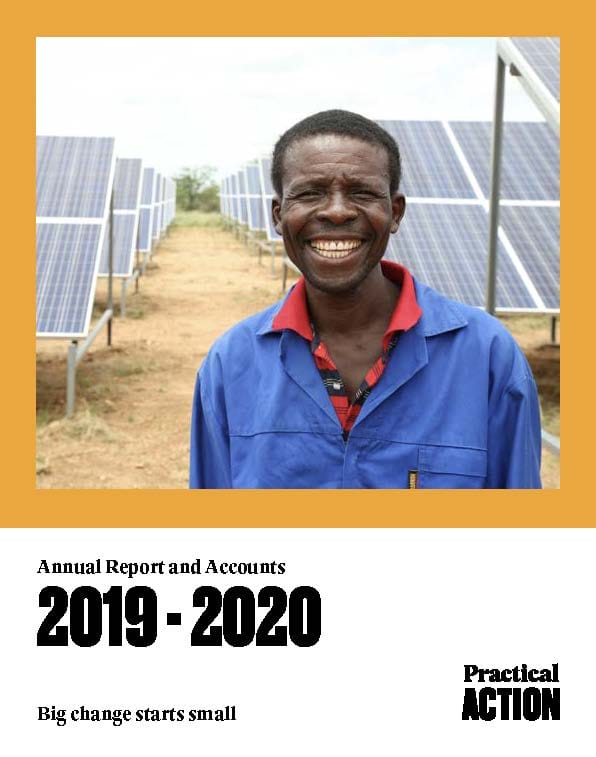 A man in a blue shirt smiles while standing in front of rows of solar panels; text reads "Annual Report and Accounts 2019-2020, Practical Action.