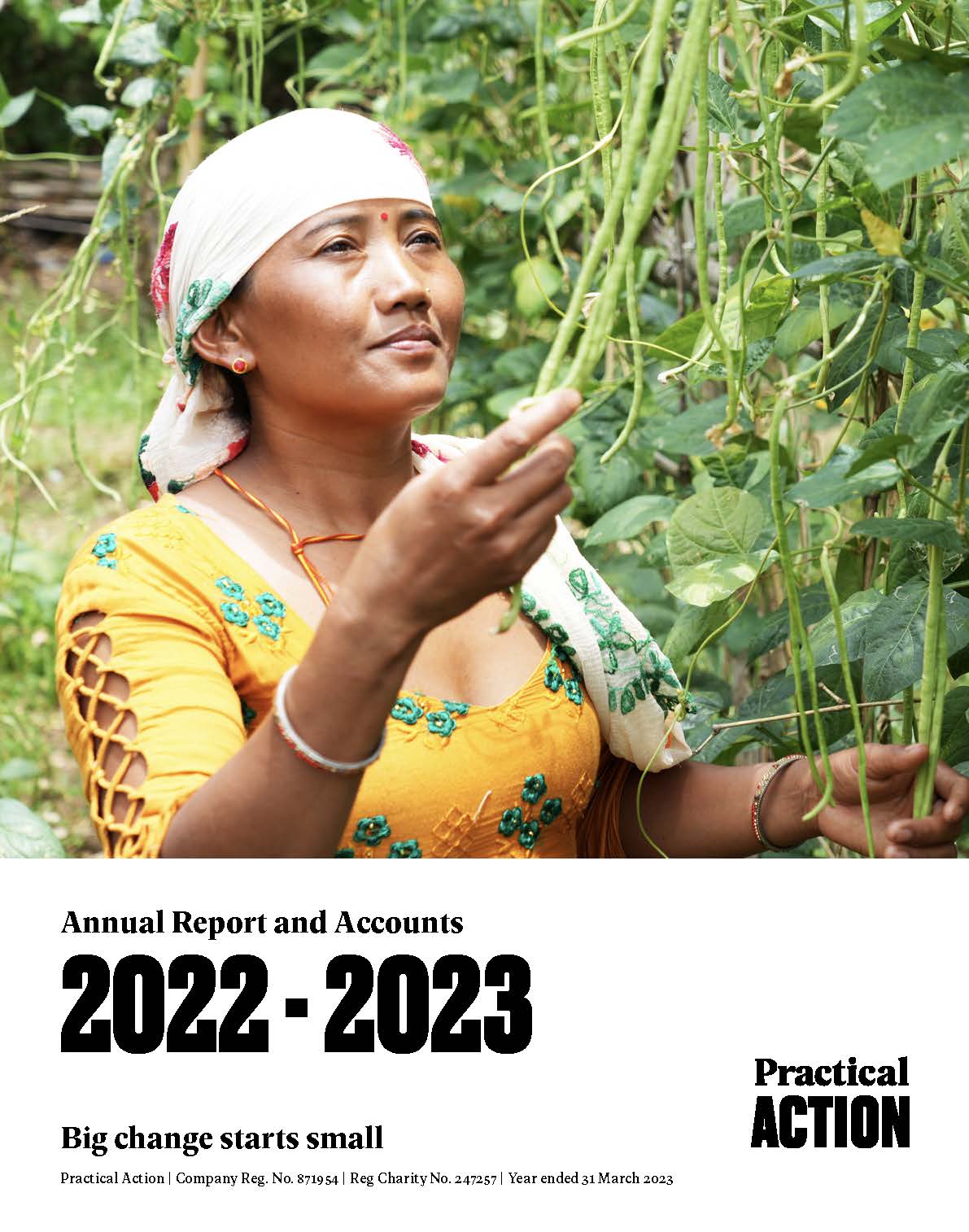 A woman in a yellow dress and white headscarf stands among green plants, reaching up, on the cover of Practical Action's 2022-2023 annual report.